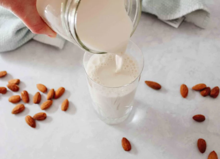 pouring a glass of almond milk
