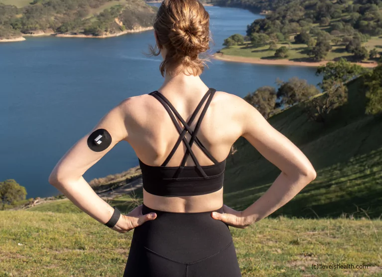 a woman standing at a lake with a Levels cgm