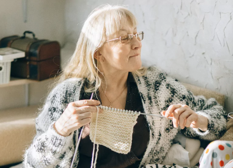 a women sitting on the couch and kitting