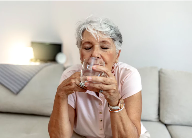 a woman drinking a glass of water