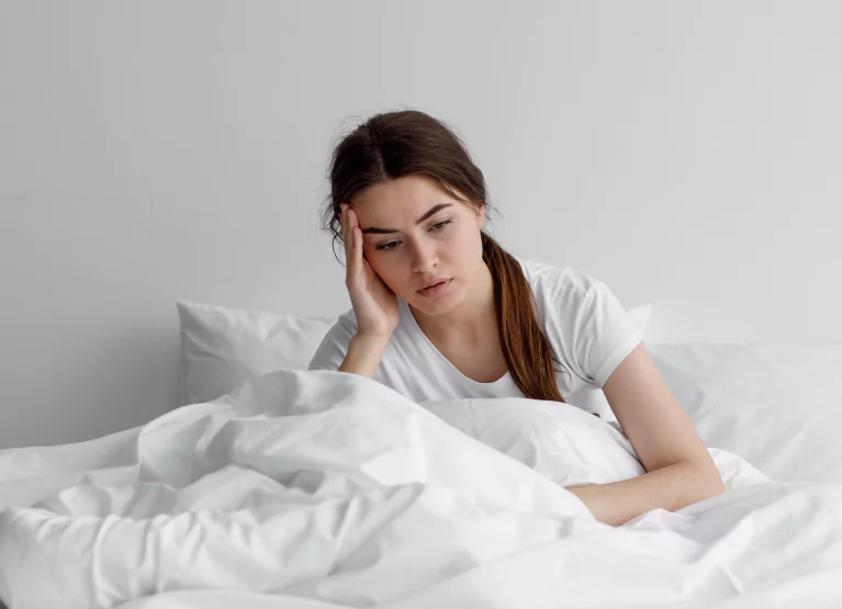 a girl looking tired in her bed