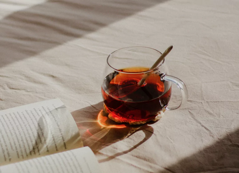 a glass of tea and a book