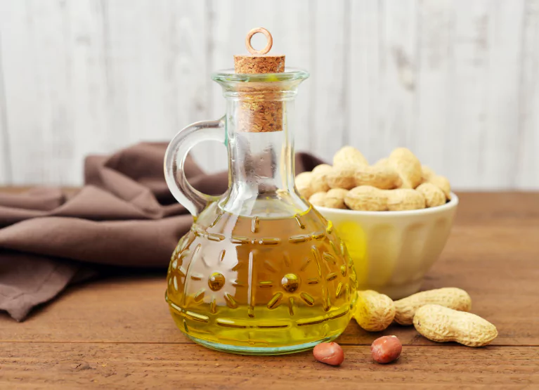 a bowl of peanuts and a jar of oil