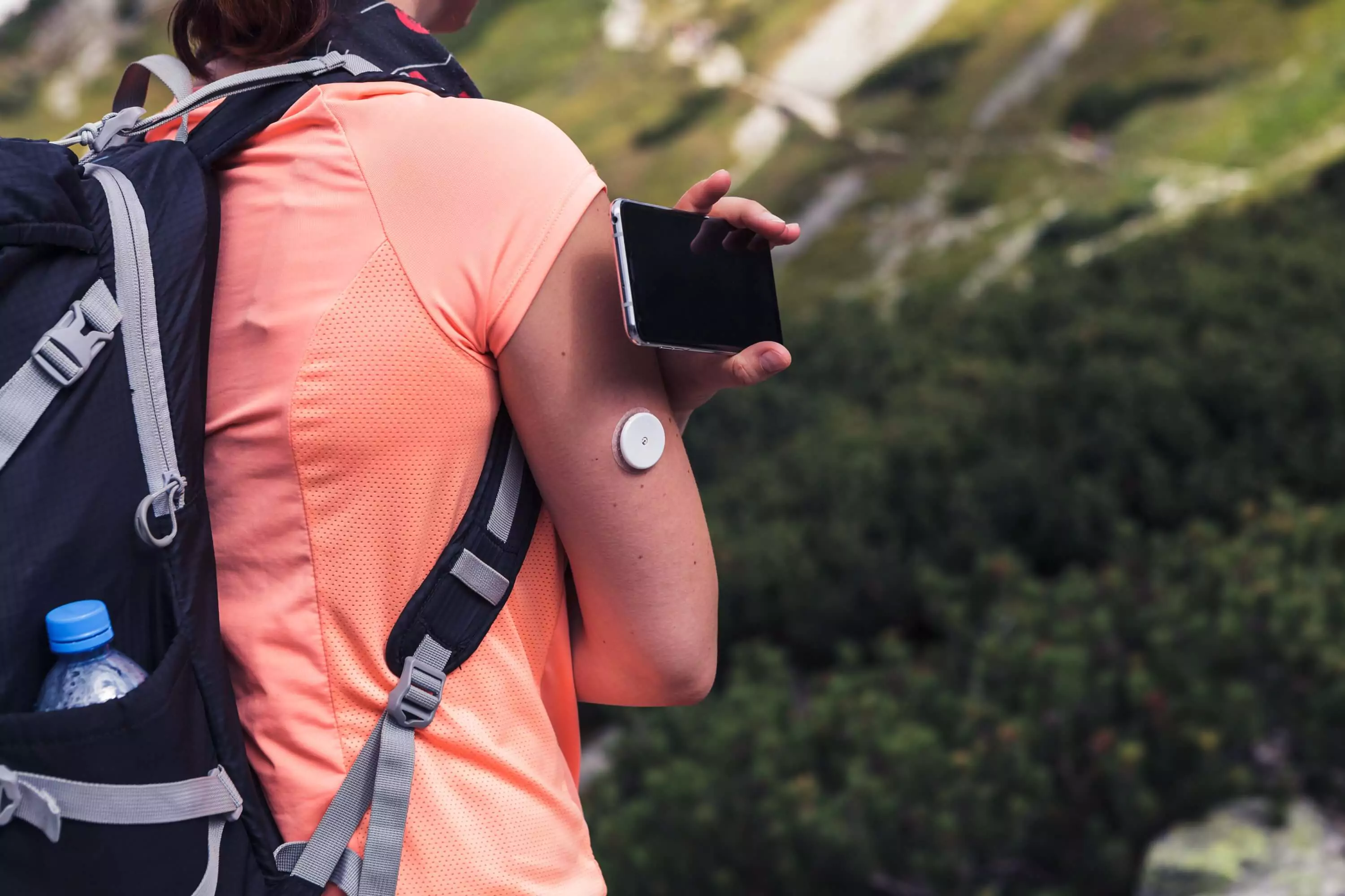 A person scanning their CGM with a smartphone
