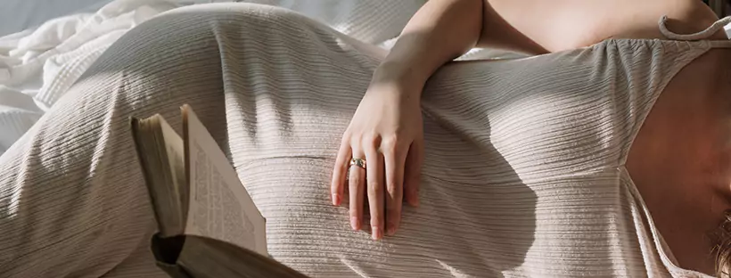 A woman lying down on her side holding her stomach