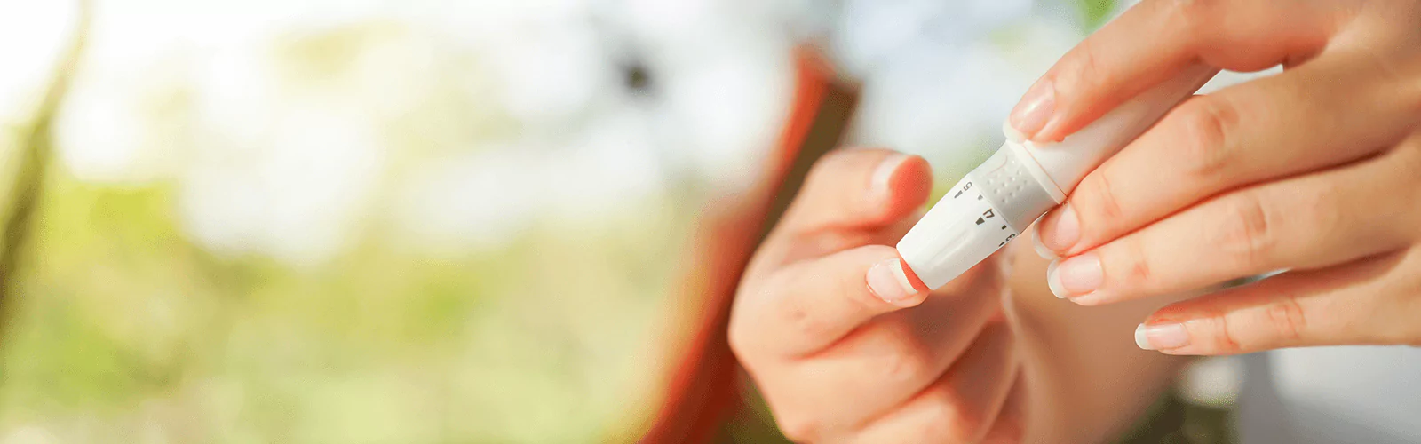 a person using finger prick method to test their glucose level