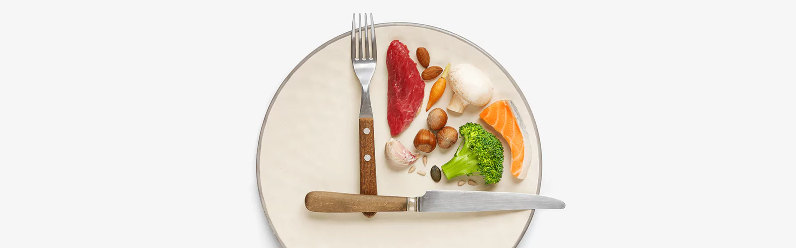 a plate of meat, fish, nuts and veggies