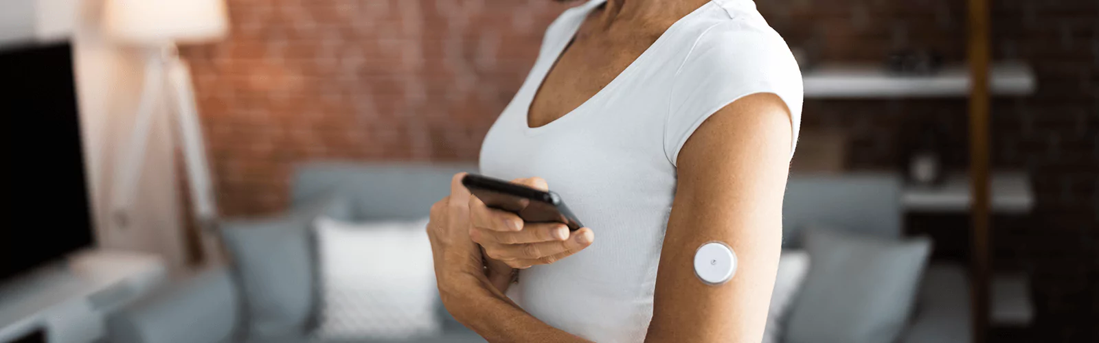 a person wearing CGM and looking at their phone