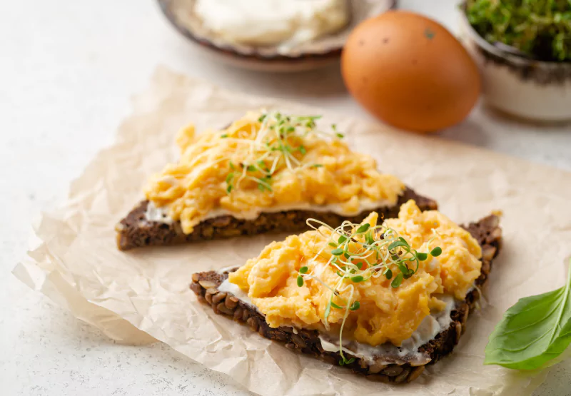 two toasts with scrambled eggs