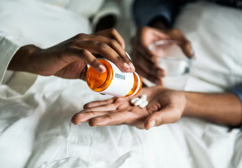 Person pouring out pills to somebody