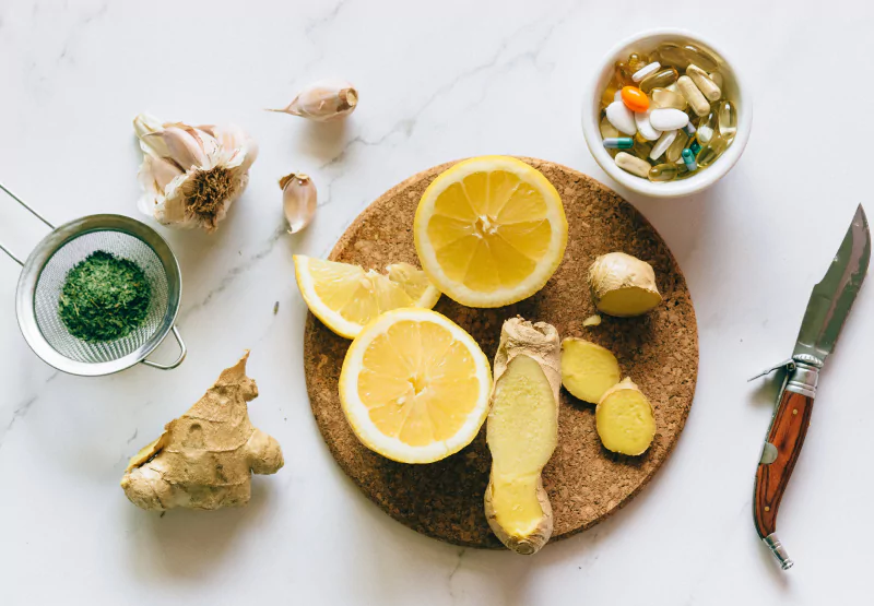 a plate of lemon, ginger, and supplements