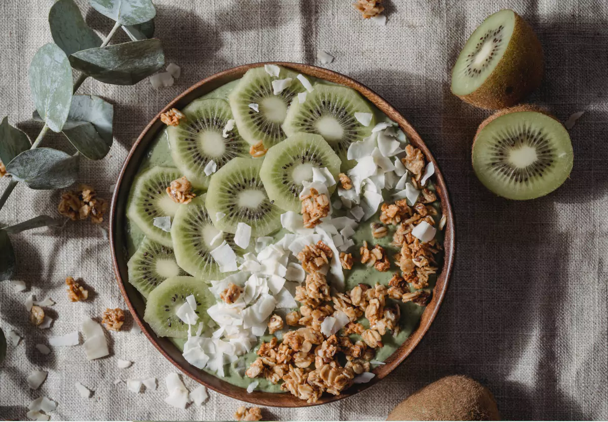 a smoothie bowl with kiwi, granola, and coconut