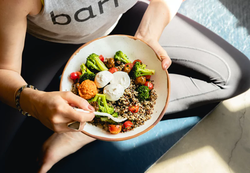 Closeup of someone eating a bowl of quinoa and vegetables