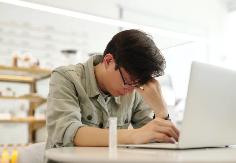 a man experiencing a headache while using a computer