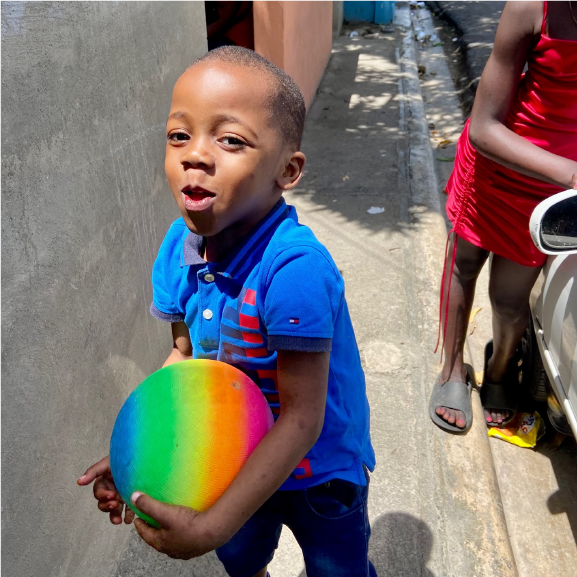 Child smiling with ball in his hands