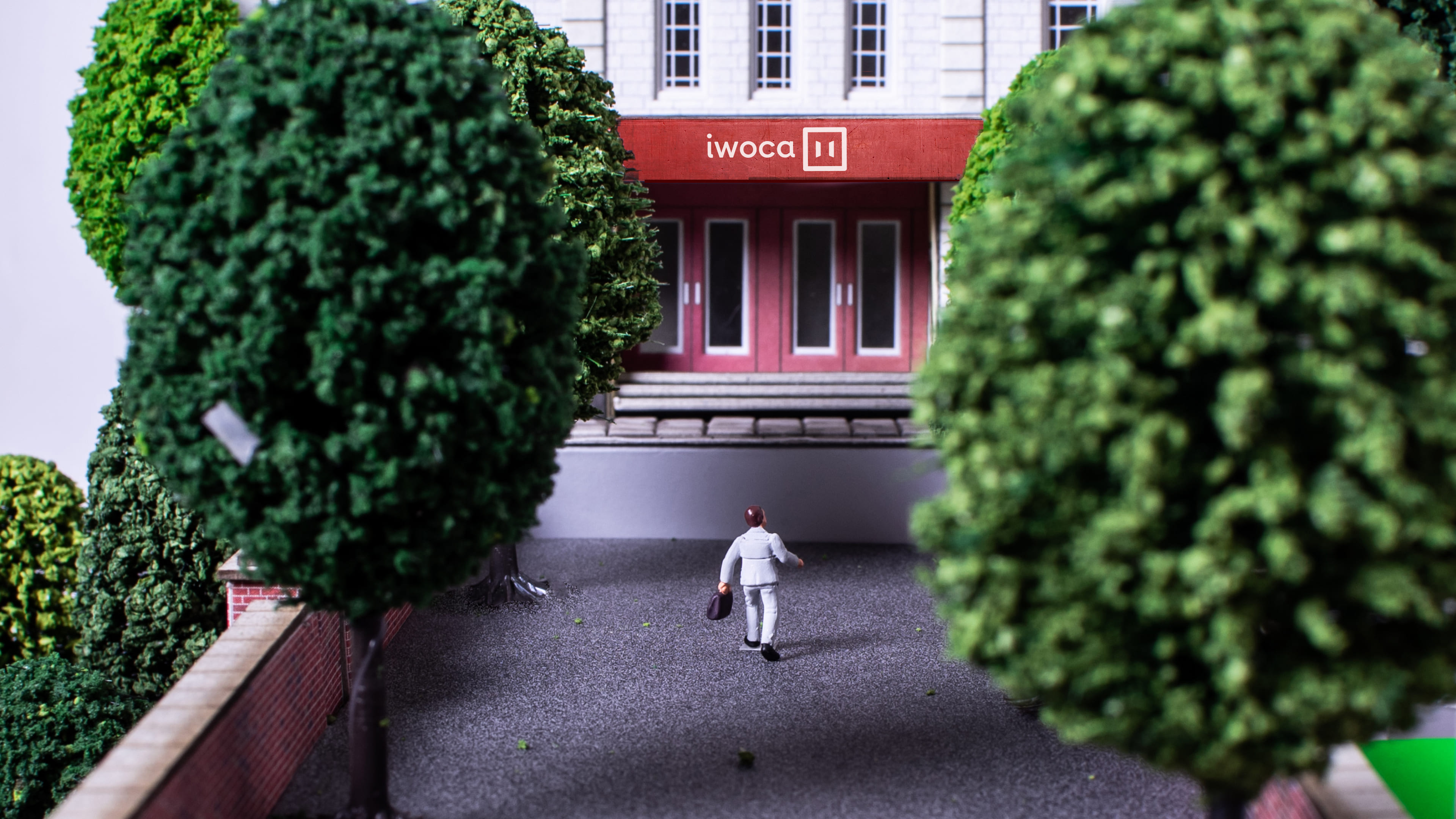 A walks towards a bank looking building with iwoca on it
