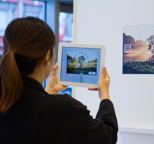 A woman taking a photo of art in an art gallery wall