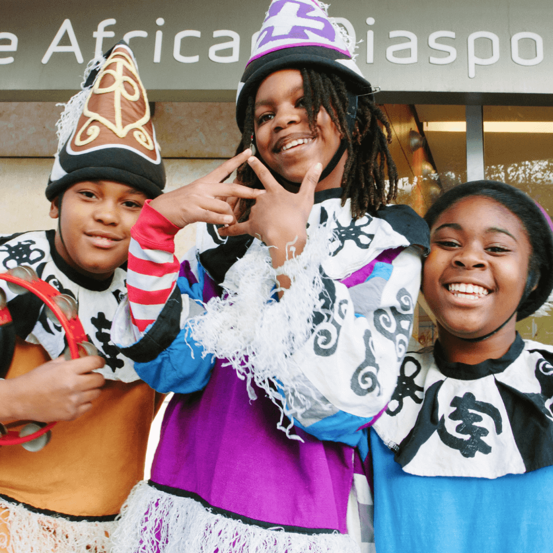 Three children smiling and dressed in costume art