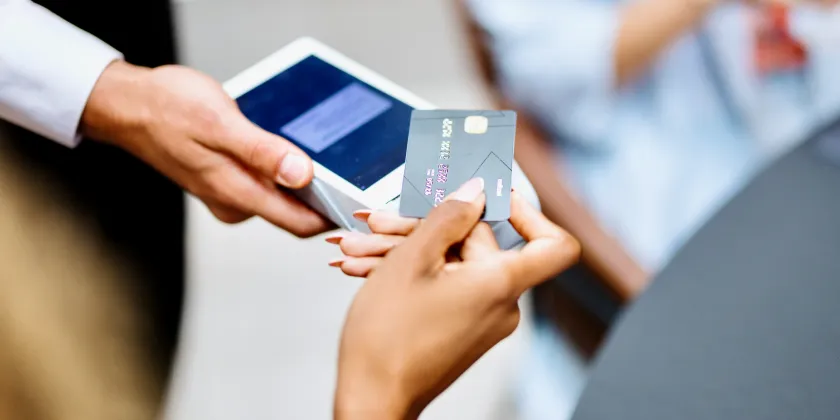 Close up of a person paying with their card by tapping it on a scanner