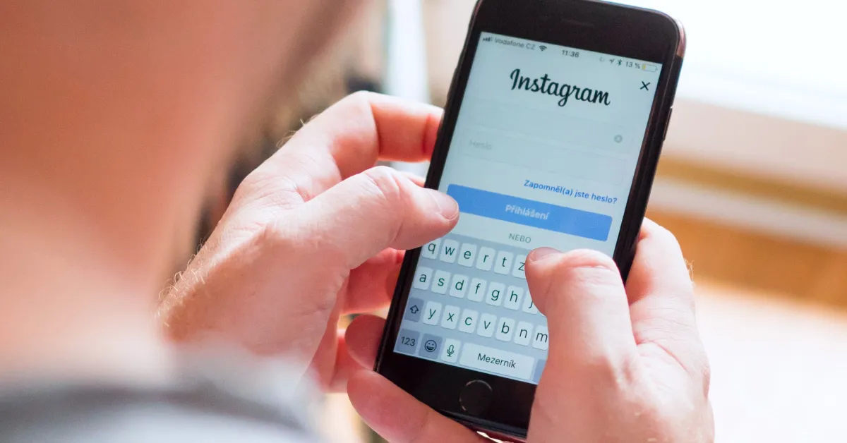 Person holding smartphone with Instagram login on display.