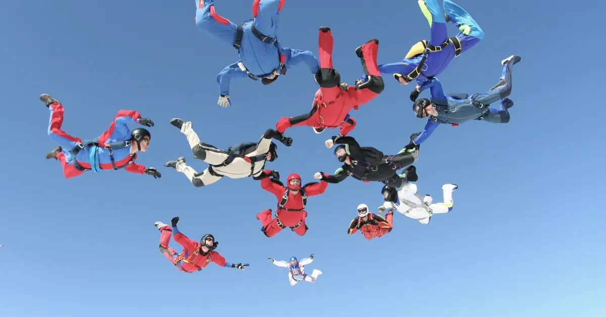 Sky divers forming a star by holding hands and feet up in the air.