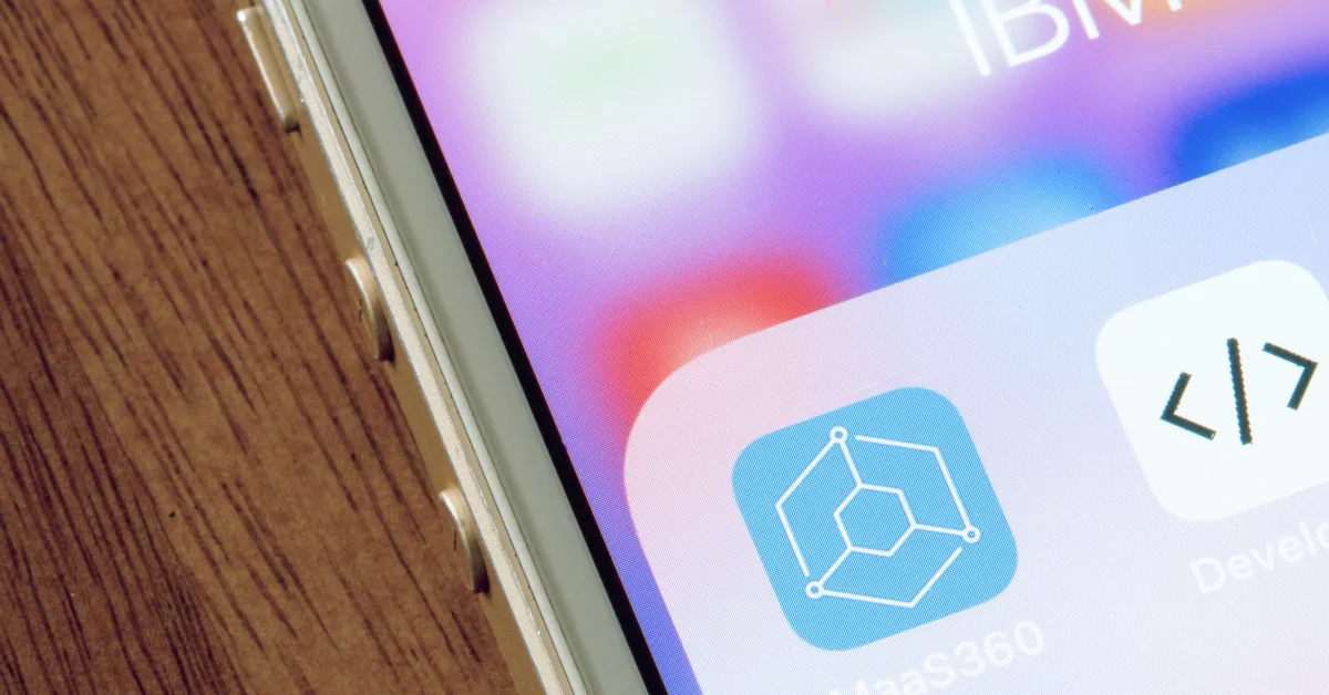Smartphone with app folder open lying on wooden table.