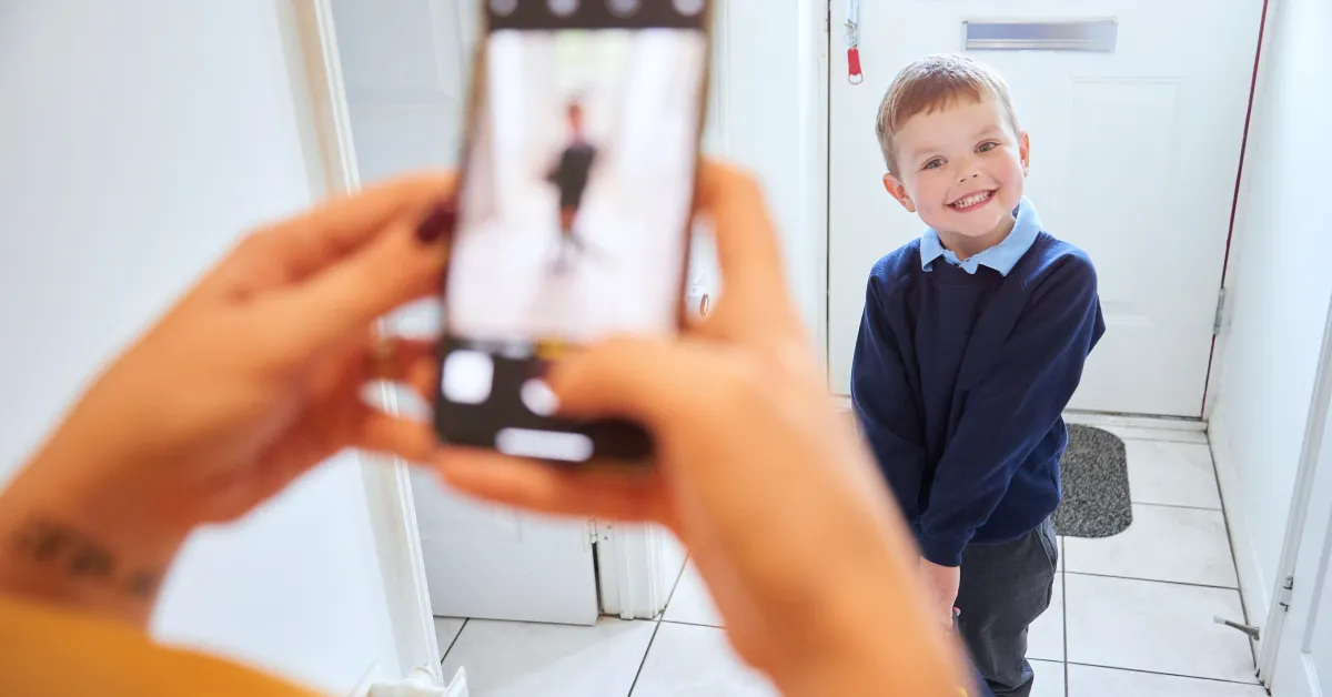 Women taking a picture of her kid using her smartphone.