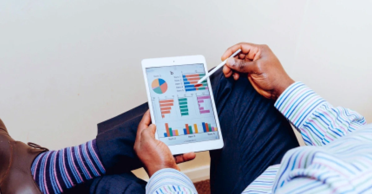 Man looking at graphs on a digital tablet.