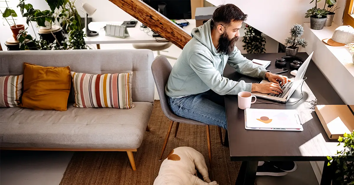 Man working from home with dog sleeping next to him.