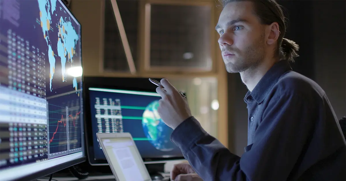 Security researcher looking intently at multiple screens showing data.