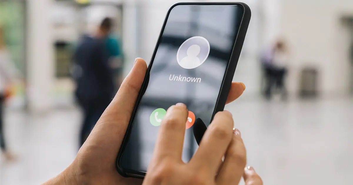 Close up of person holding phone getting a call from an unknown person.