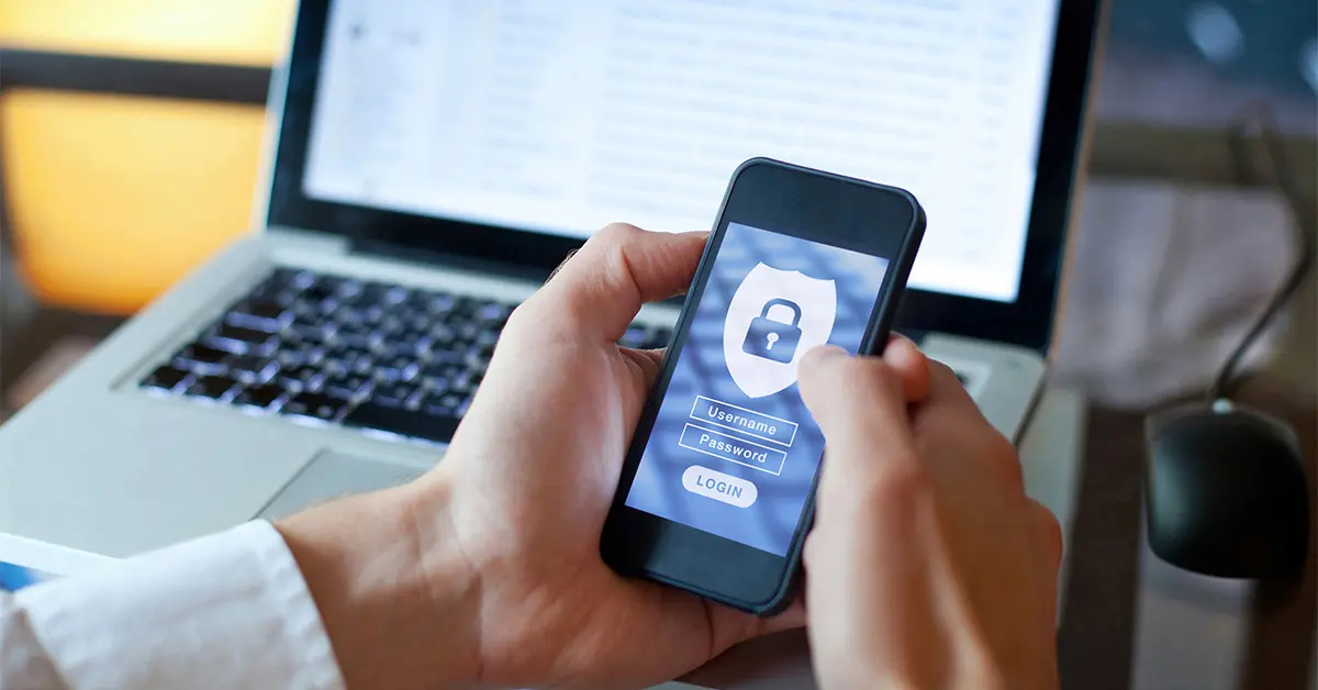 Close up of a person holding a phone with a security app running.