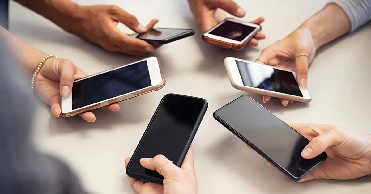 People holding their phones out forming a circle in the middle.