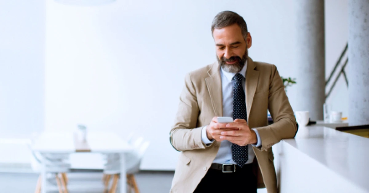 Businessman using mobile phone in modern office.