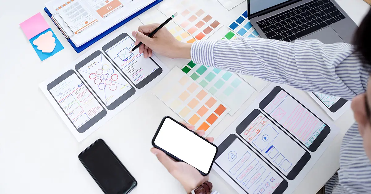 Person designing and developing an app with paper prototypes.