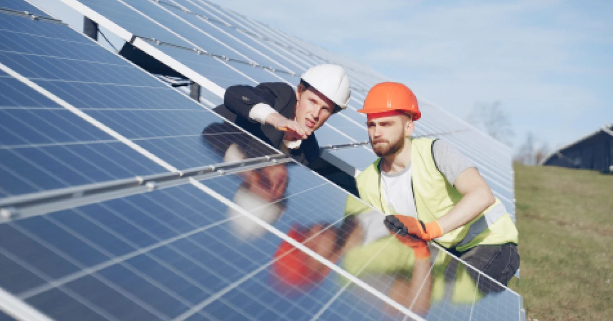 Electricians inspecting a bank of solar panels.