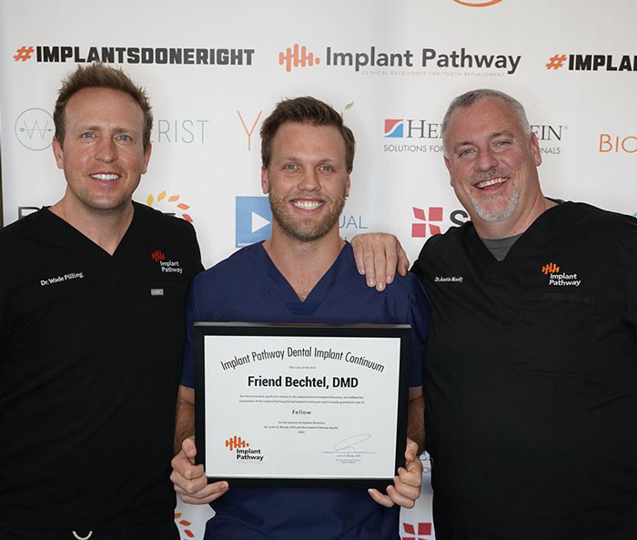 Dr Friend holding certificate at Implant Pathway event