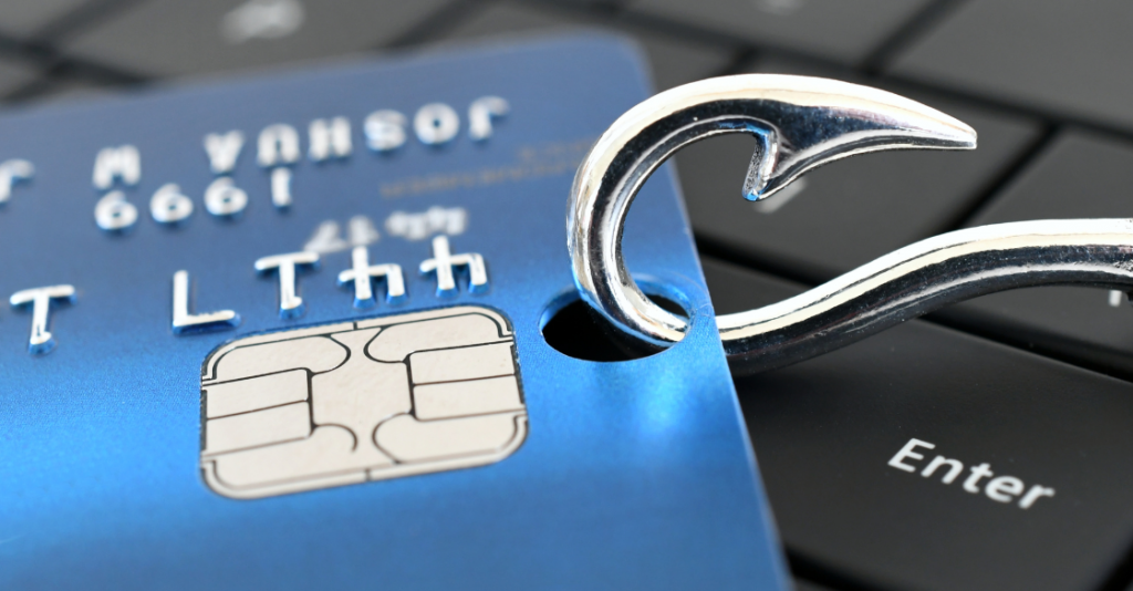 Fish hook in credit card sitting on a laptop