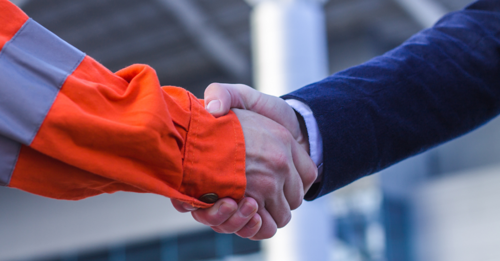 Business person and worker shaking hands