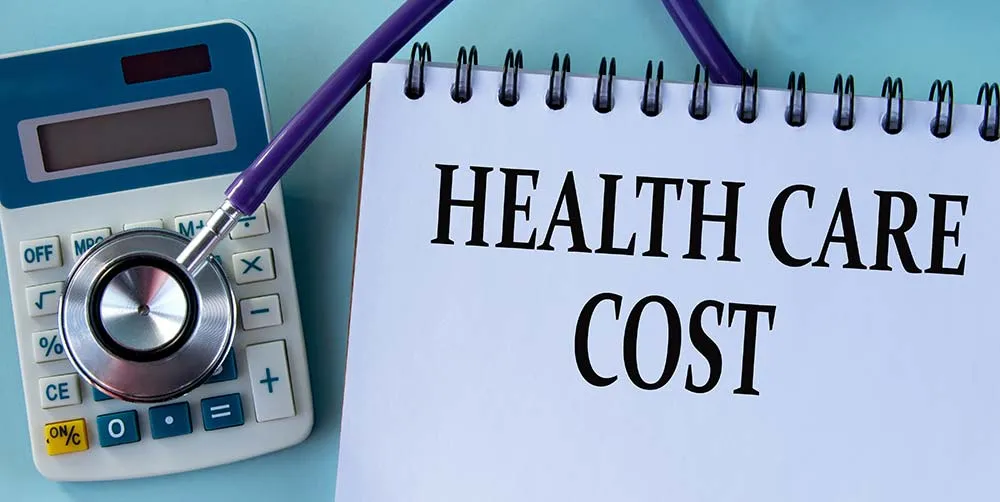 calculator next to a notepad written health care cost