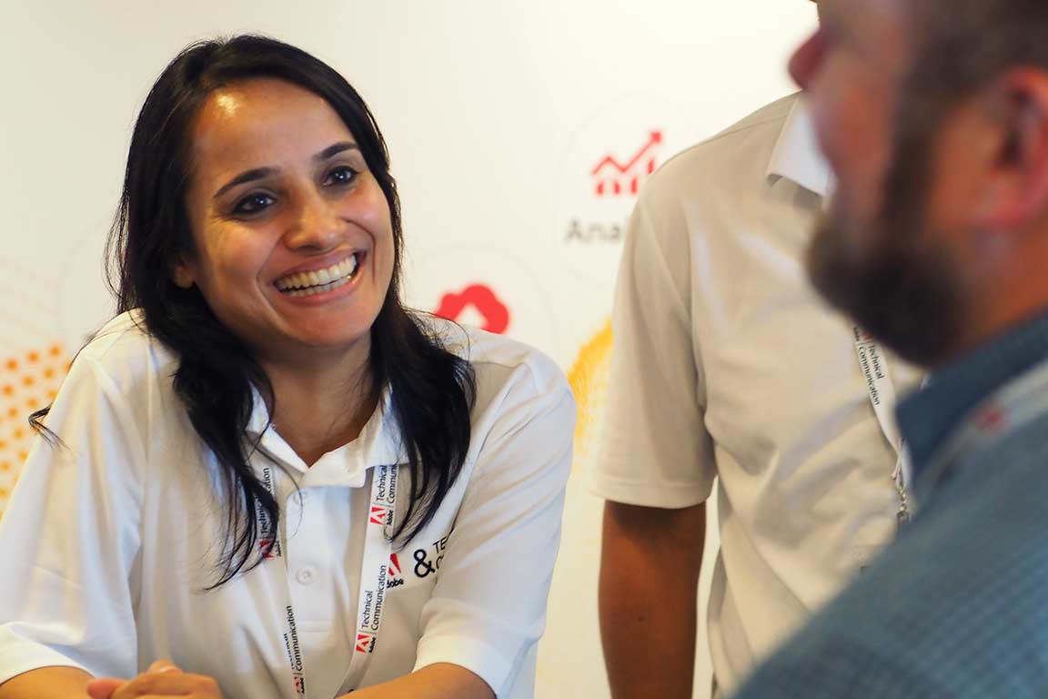Photo of a sponsor talking to an attendee at Confab