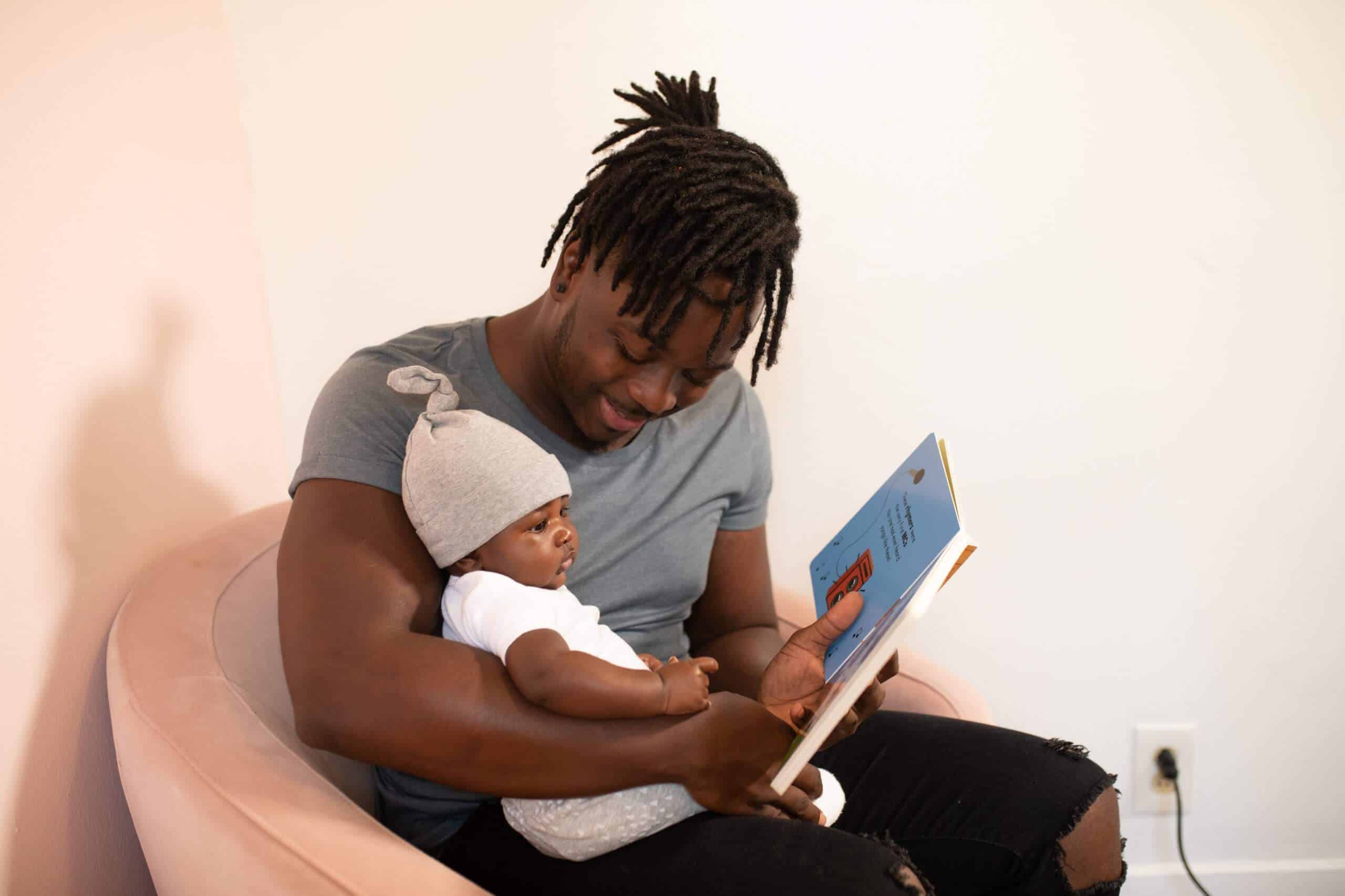 How Employers Can Care for Caregivers - man holding baby and reading book