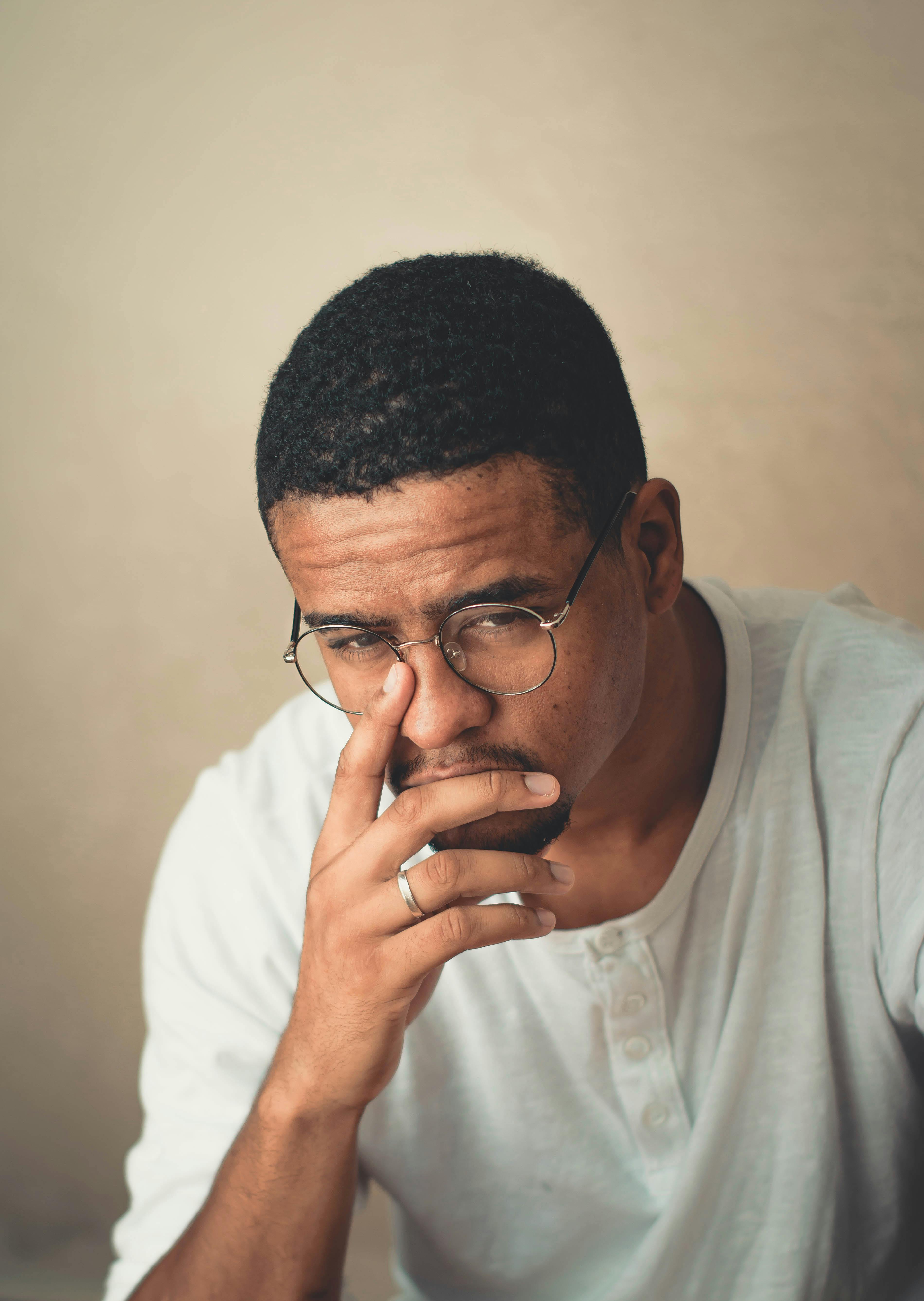 Man sitting and worrying with hand on his face.