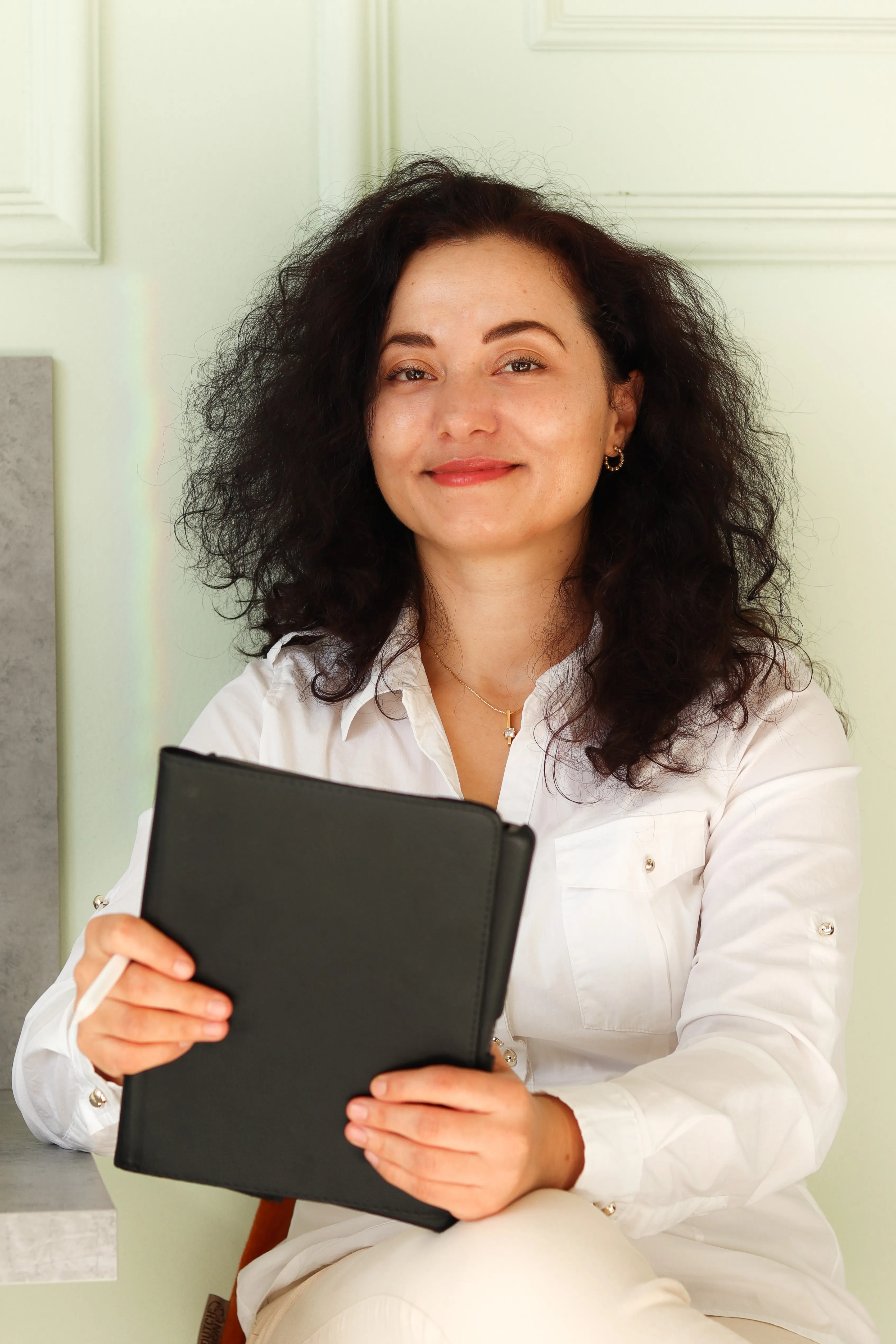 Profile picture of Nikoleta Angelova sitting in a caffe, holiding and iPad