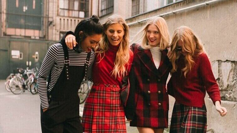 Group of young girls wearing plaid outfits laughing