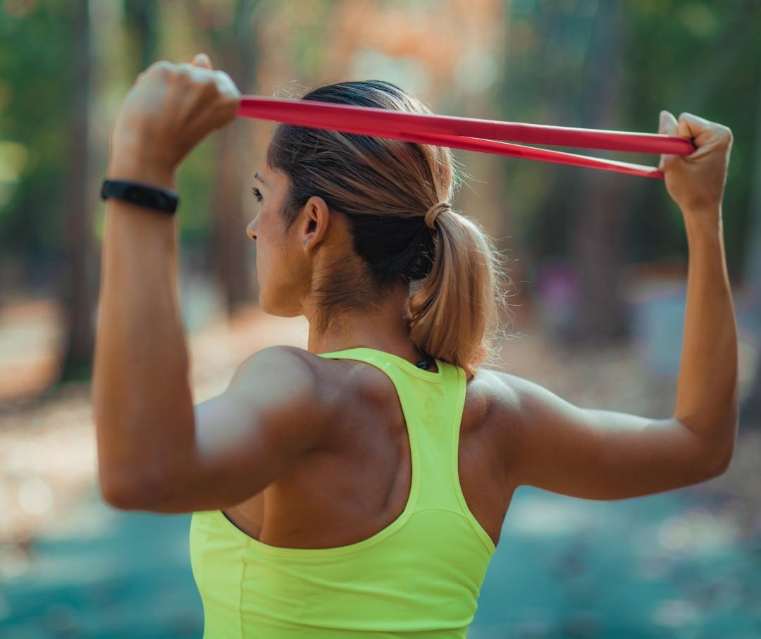 woman exercising her shoulders with an exercise band