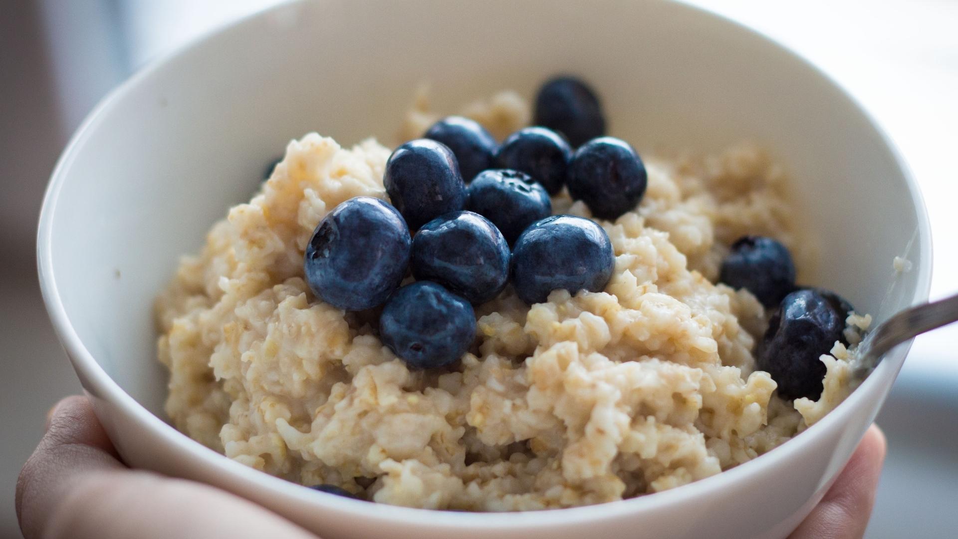 A bowl of oatmeal with blueberries.