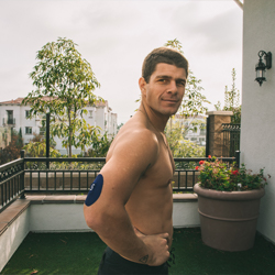man standing casually on a patio; wearing a Signos CGM
