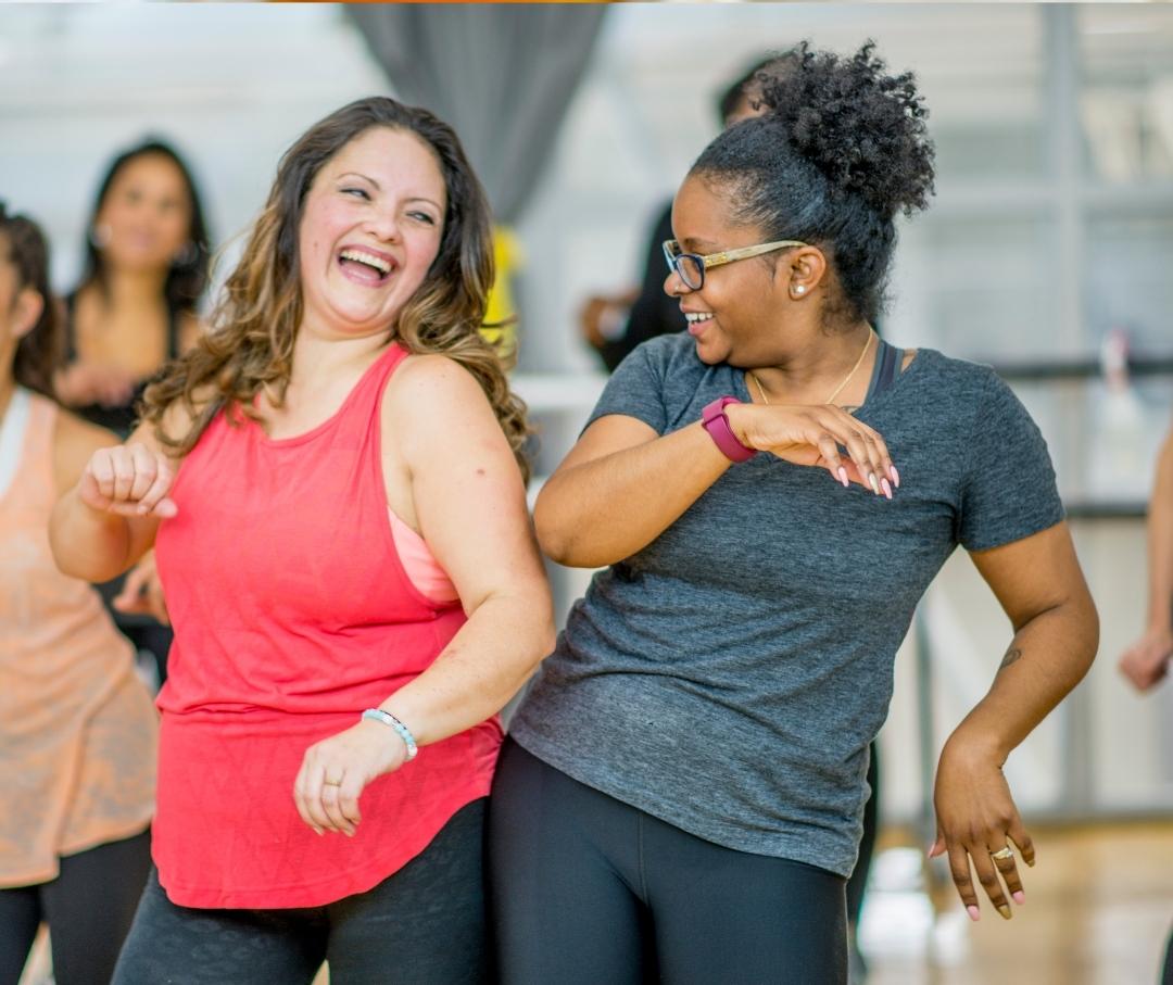 women dancing and smiling in a fitness class