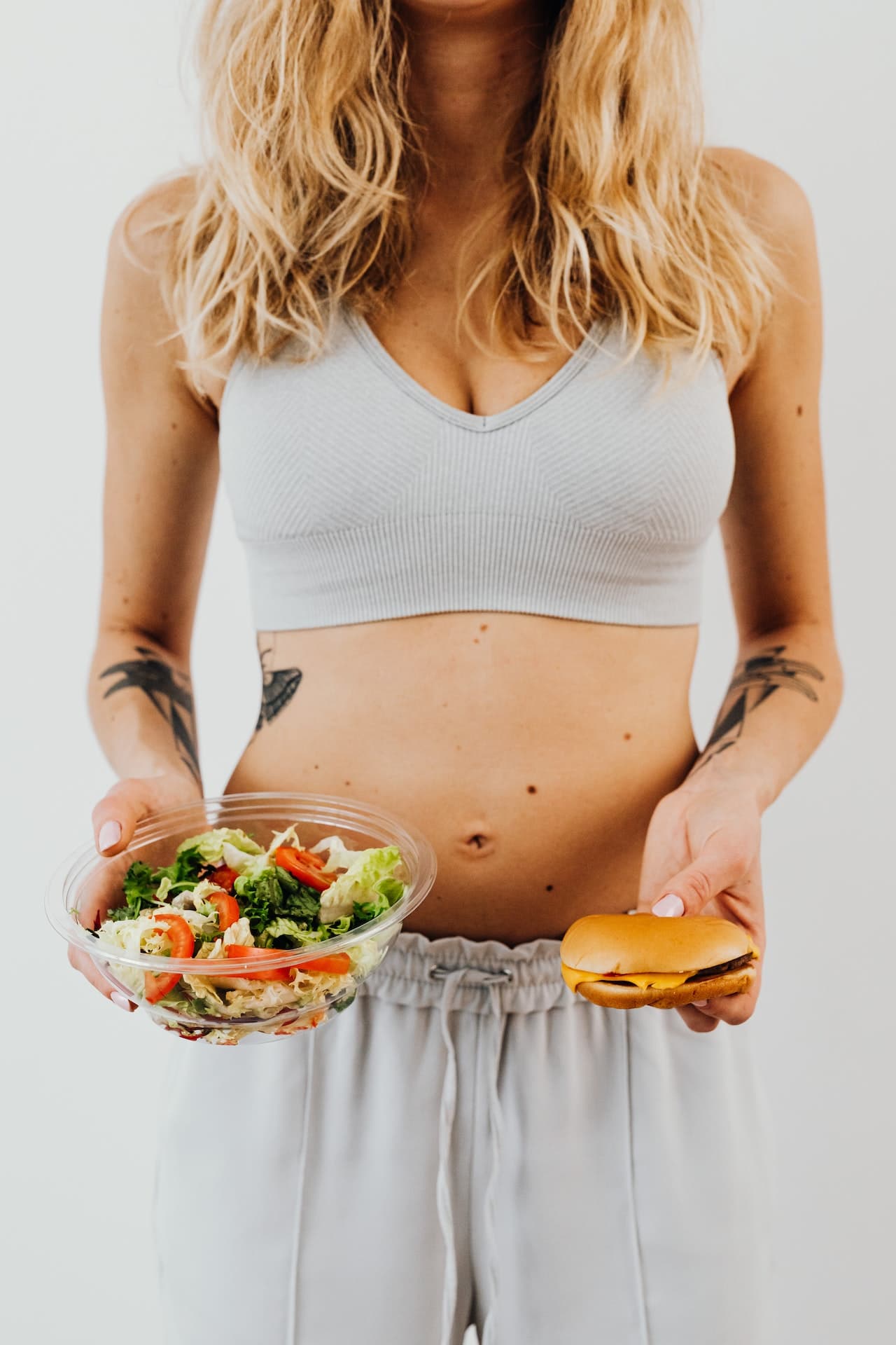 Woman-Holding-Burger-and-Bowl-of-Salad